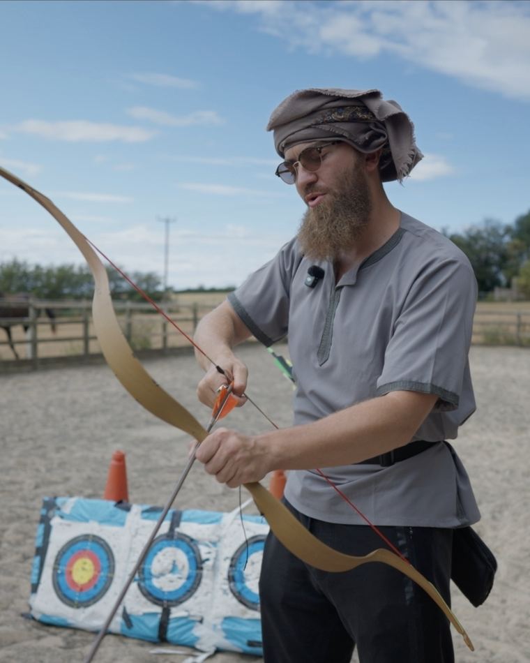 Drawing a traditional bow at the target in the arena